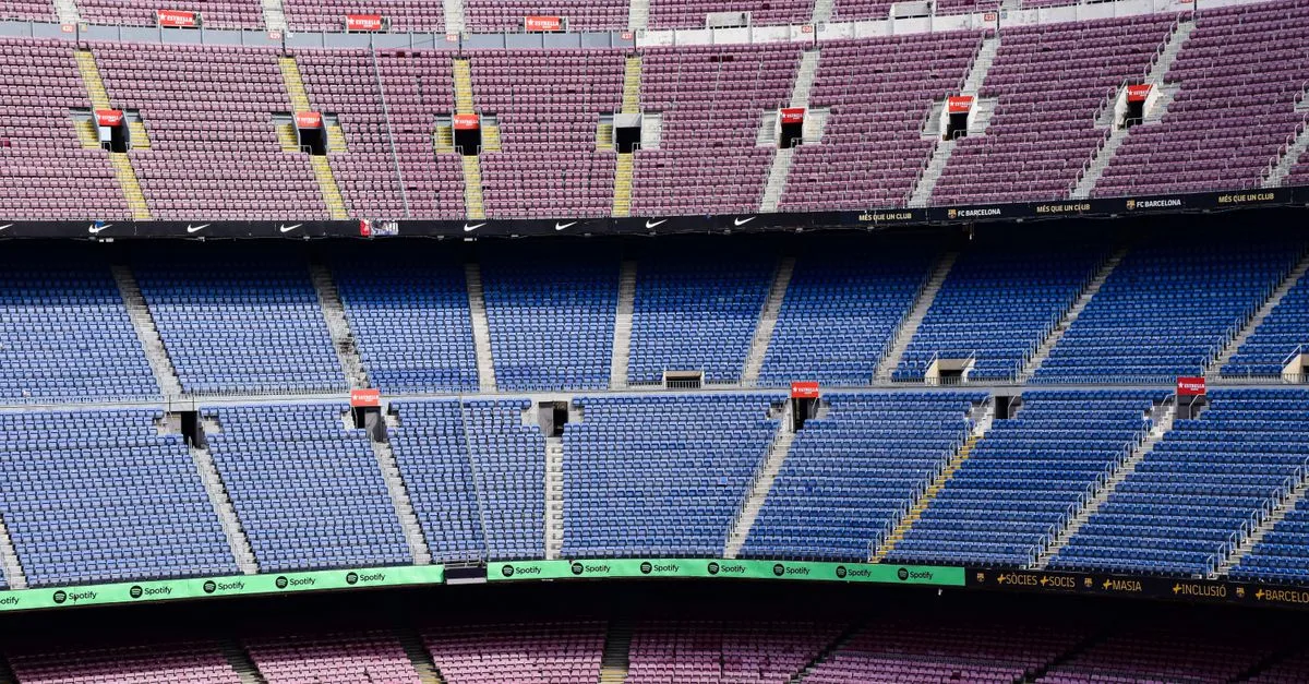 Panoramic view of empty seats in the iconic Barcelona football stadium with vibrant seating arrangement.