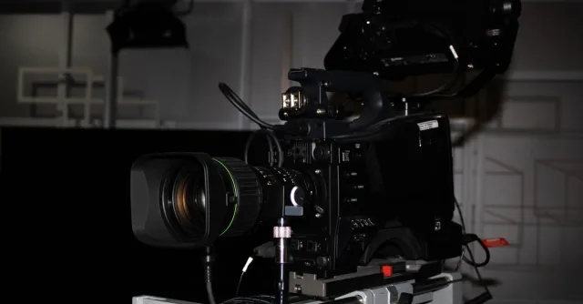 Close-up of a professional video camera rig in a studio environment, highlighting its complexity.