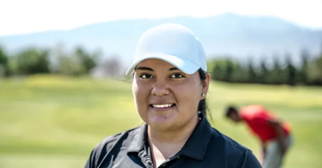 A woman golfer enjoys a sunny day on the golf course, showcasing her passion for the sport.