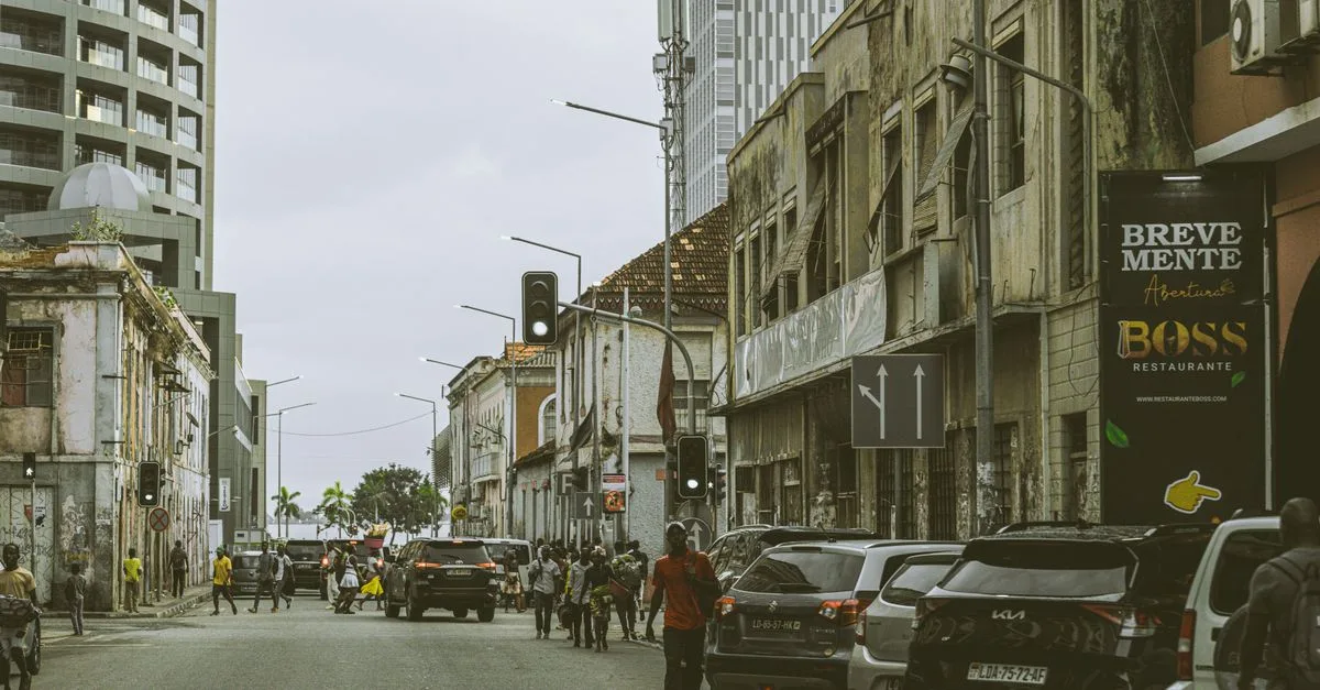 Bustling street scene in downtown Luanda, Angola with historic and modern buildings.