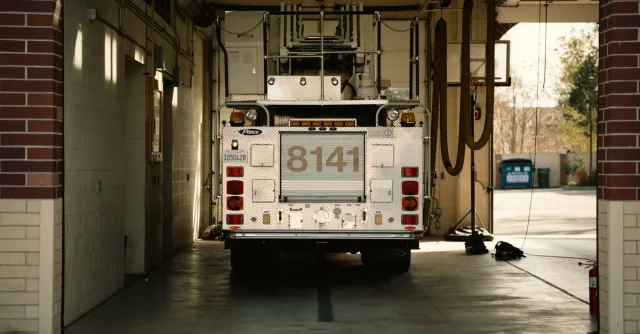 A fire truck parked inside a station's garage, showcasing emergency preparedness.