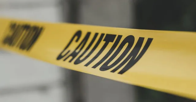 Close-up image of yellow caution tape with blurred background, emphasizing warning and safety.