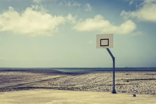 A professional basketball court with bright lighting and polished hardwood floors.