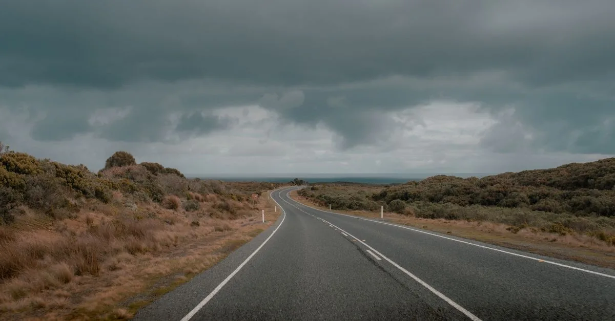 Empty road under dramatic clouds in Anglesea, Australia. Perfect for travel and nature themes.