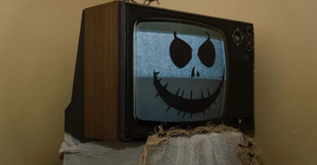 Retro TV adorned with a spooky Halloween face, creating a nostalgic eerie vibe.