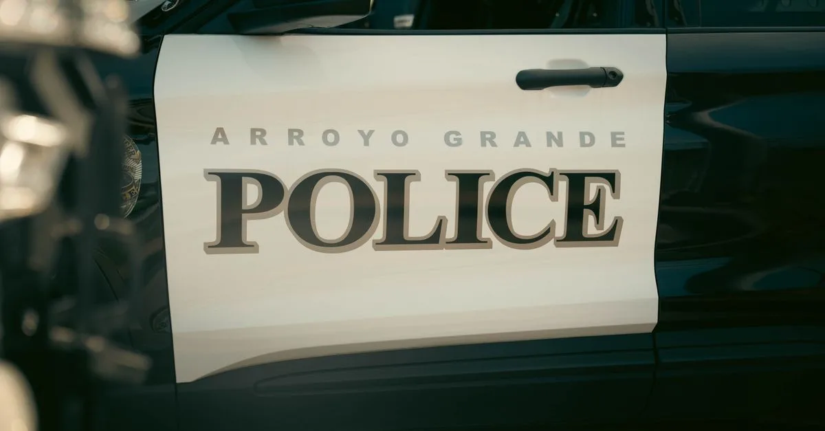 Close-up view of Arroyo Grande Police car door, showcasing bold text and design.