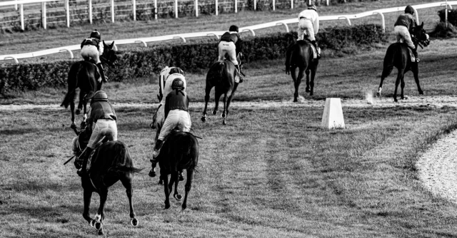 Black and white photo of horse racing at a track in Wrocław, Poland.