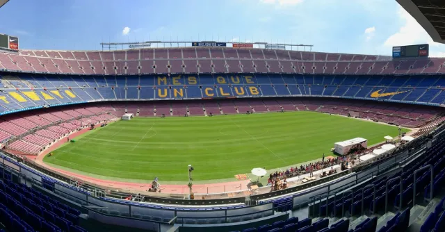 Panoramic view of Camp Nou stadium showcasing its iconic seating and field.