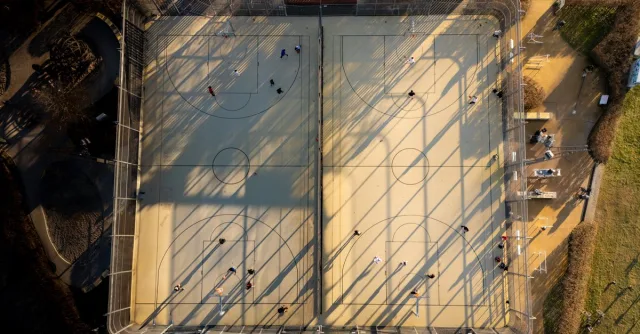 Drone shot of basketball courts in Frankfurt, Germany, showing people playing.
