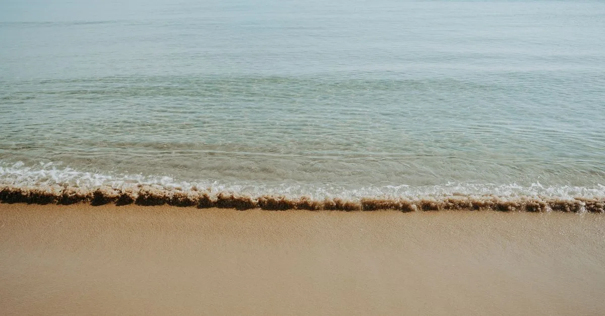 Calm and serene beach with gentle waves lapping on the sandy shore. Perfect for relaxation.