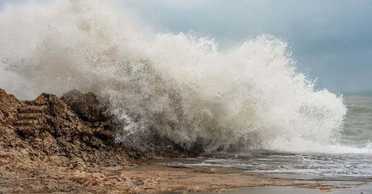 Powerful waves crash on the rocky coast of Cullera, Spain, showcasing nature's strength.