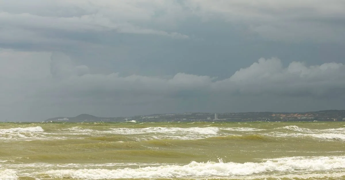 A captivating view of the ocean under a stormy sky. Turbulent waves and dark clouds create a dramatic seascape.