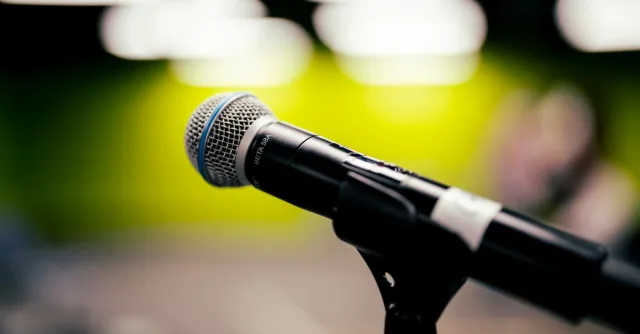 A detailed shot of a microphone on stage, perfect for audio and music themes.