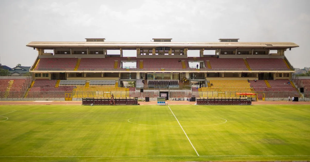 A wide view of the empty Baba Yara Sports Stadium in Kumasi, showcasing its structure and green field.
