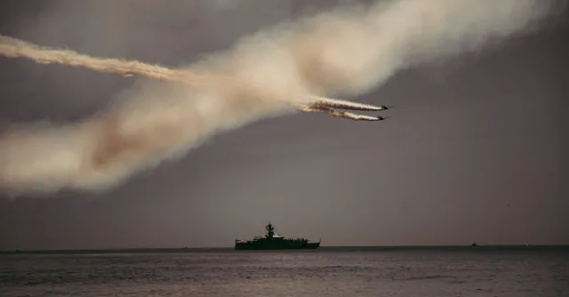 Spectacular airshow in New York Harbor with fighter jets and a ship.