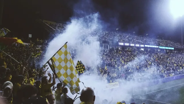 A professional soccer stadium illuminated at night.