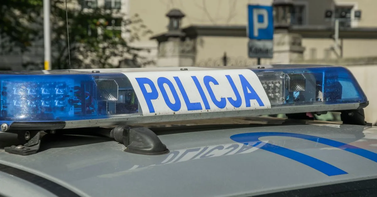 A close-up image showing the light bar of a Polish police car with the word 'Policja'.