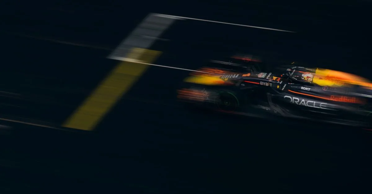 Blurred image of a Formula One car racing down the track, showcasing speed and motion.