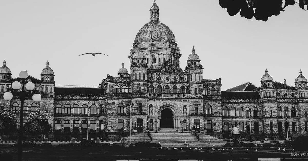 Black and white photo of the Parliament Building in Victoria, BC, showcasing its historic architecture.