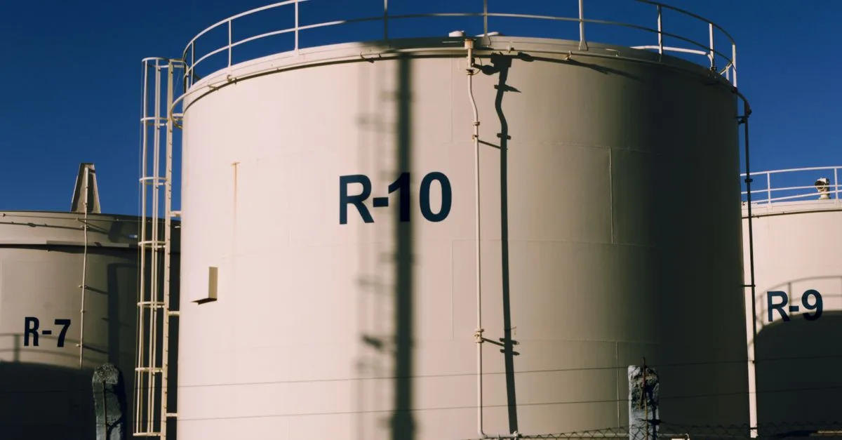Large industrial storage tanks under blue skies, highlighting metal structures.
