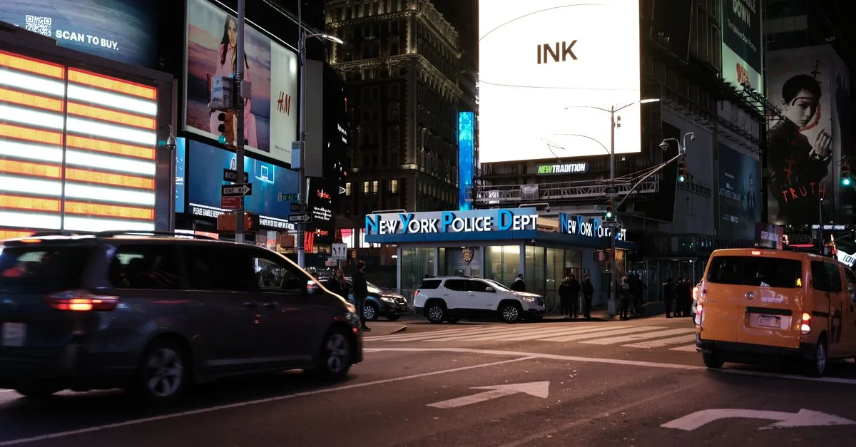 Dynamic shot of Times Square at night with bustling traffic and iconic neon signs.