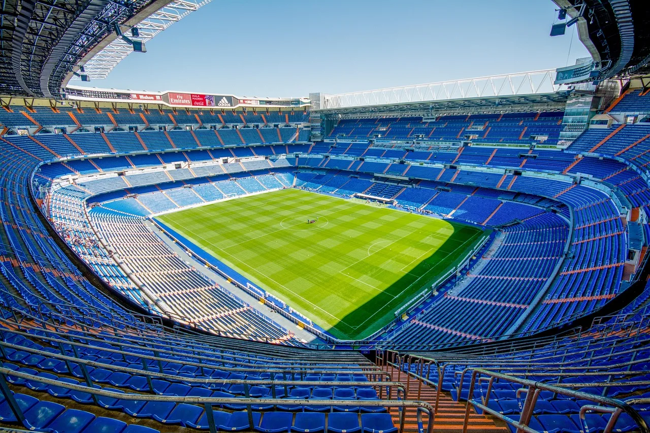 A professional football stadium lit up at night for an international match.