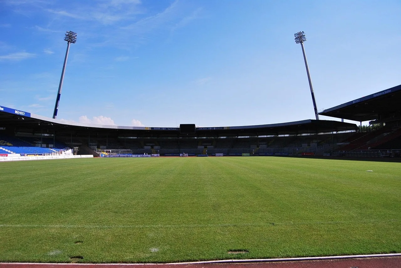 A professional football stadium illuminated by bright floodlights at night.