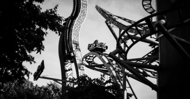 A thrilling black and white image of a roller coaster in Wien, capturing the excitement and motion.