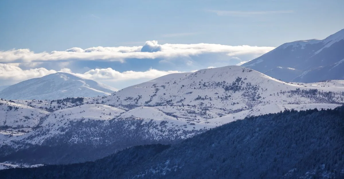 Breathtaking view of snow-capped mountains in winter under a clear blue sky.