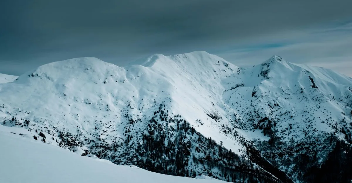 Breathtaking view of snow-capped mountains under a moody winter sky.