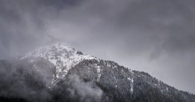 A stunning view of snowcapped mountains amidst clouds in Habach, Austria.
