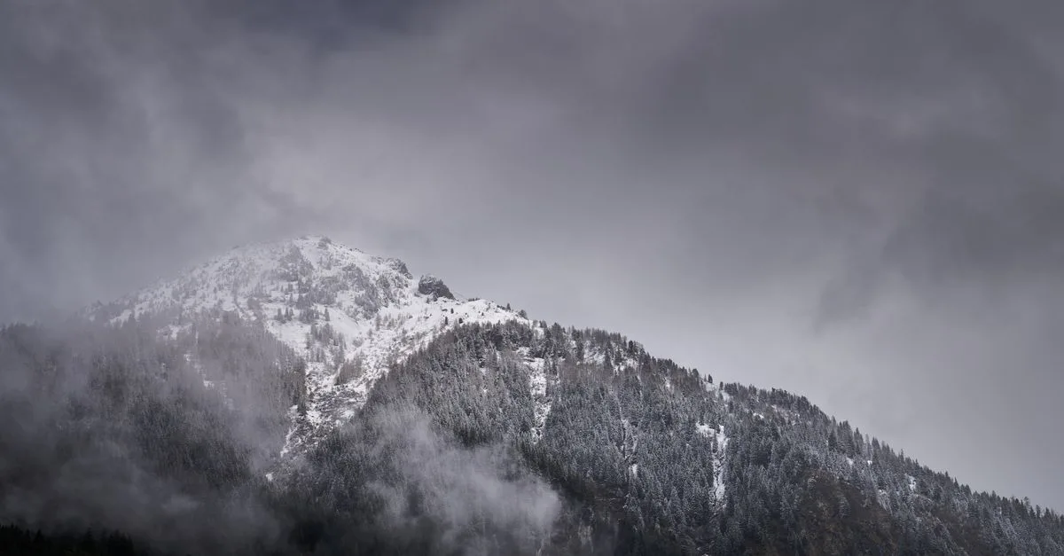 A stunning view of snowcapped mountains amidst clouds in Habach, Austria.