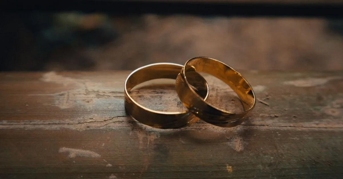 Beautiful gold wedding rings placed elegantly on a rustic wooden surface.