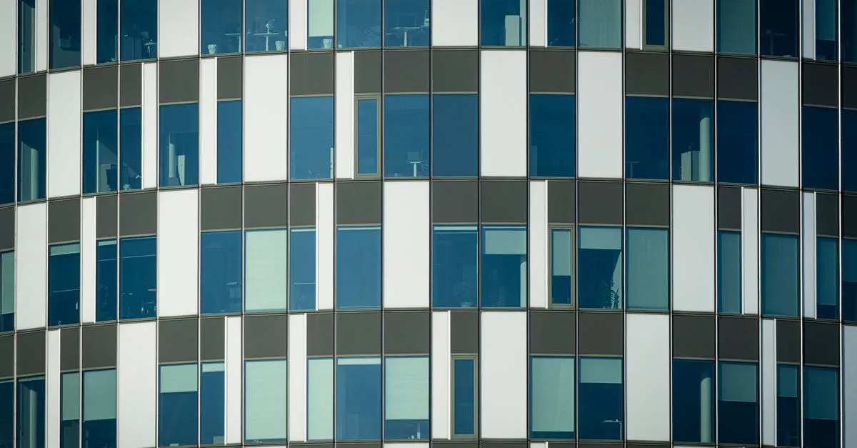 Close-up of a modern office building facade with geometric patterns and glass windows.