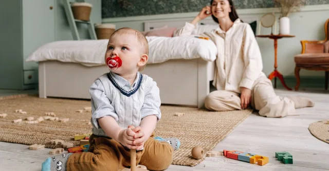 Mom and son enjoying playtime indoors with wooden toys, capturing the essence of family bonding.