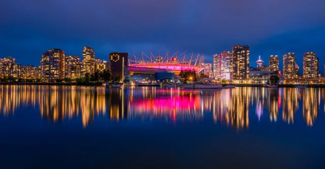 Stunning night view of Vancouver skyline with illuminated BC Place reflected in False Creek.