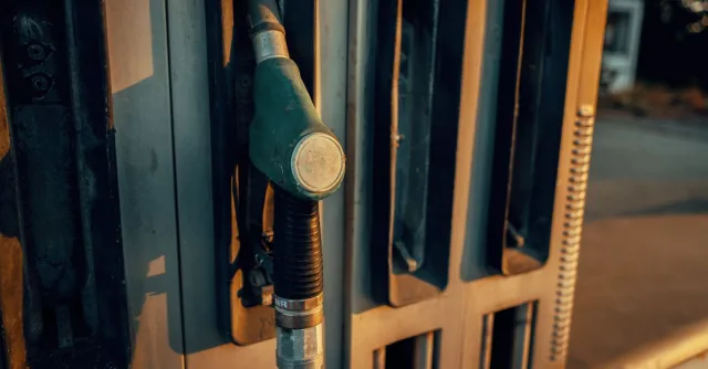 A detailed view of a gas pump nozzle during sunset in Österreich, highlighting industrial design.