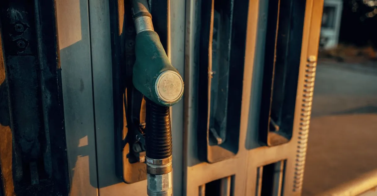 A detailed view of a gas pump nozzle during sunset in Österreich, highlighting industrial design.