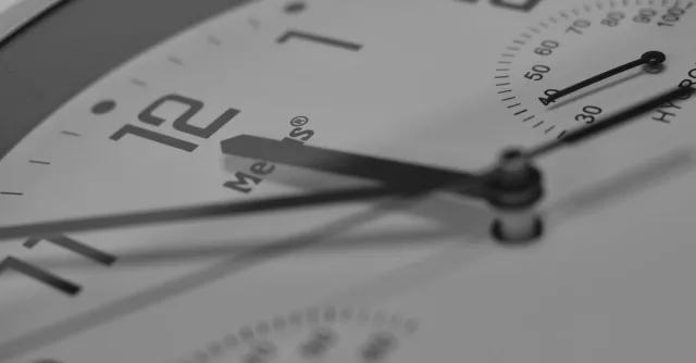 Detailed close-up of an analog clock face showing numbers and clock hands.