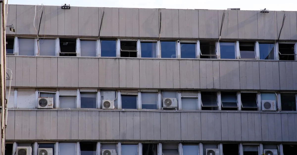 Urban building facade with multiple windows and air conditioners in İzmir, Türkiye.