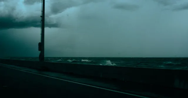 Dramatic seascape with stormy skies seen from a highway along the coast, capturing nature's intensity.