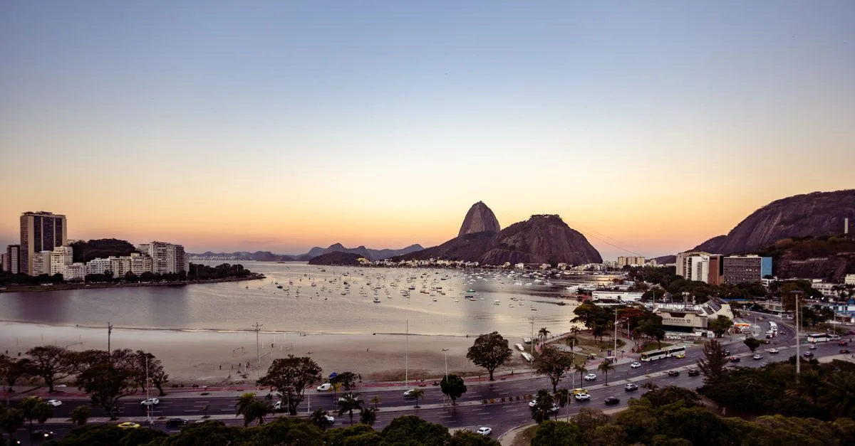 A breathtaking aerial view of Botafogo Beach, Rio de Janeiro, with Sugarloaf Mountain at sunset.